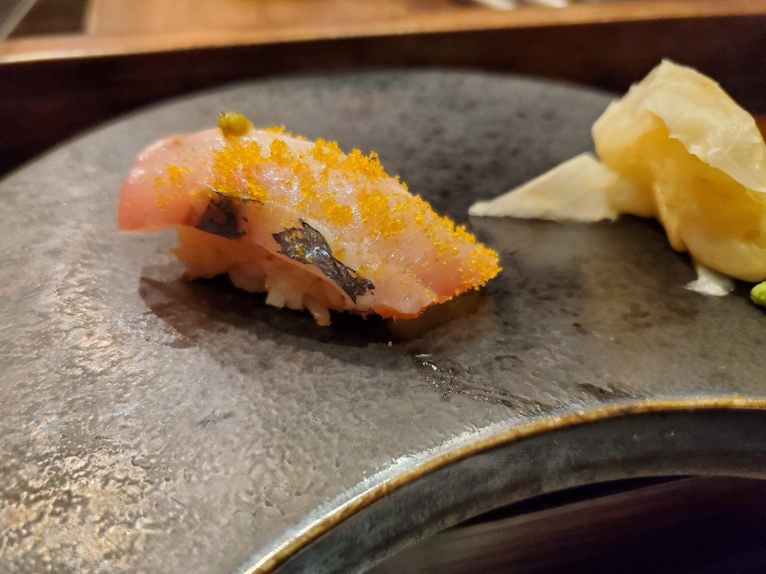 Nigiri finished with a bright roe garnish